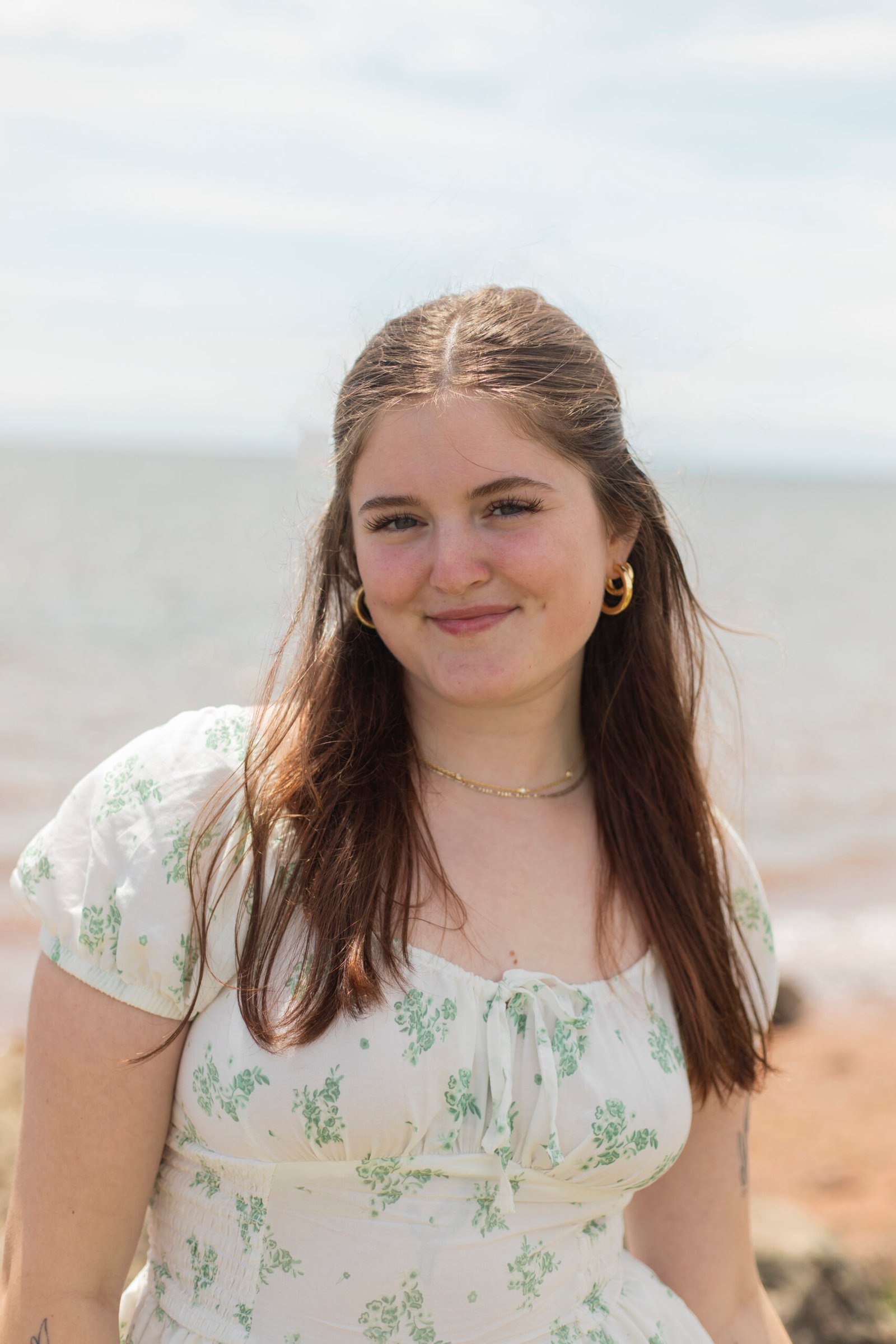 Ottawa wedding photographer Melanie smiling during a photography session on a scenic beach in Prince Edward Island.