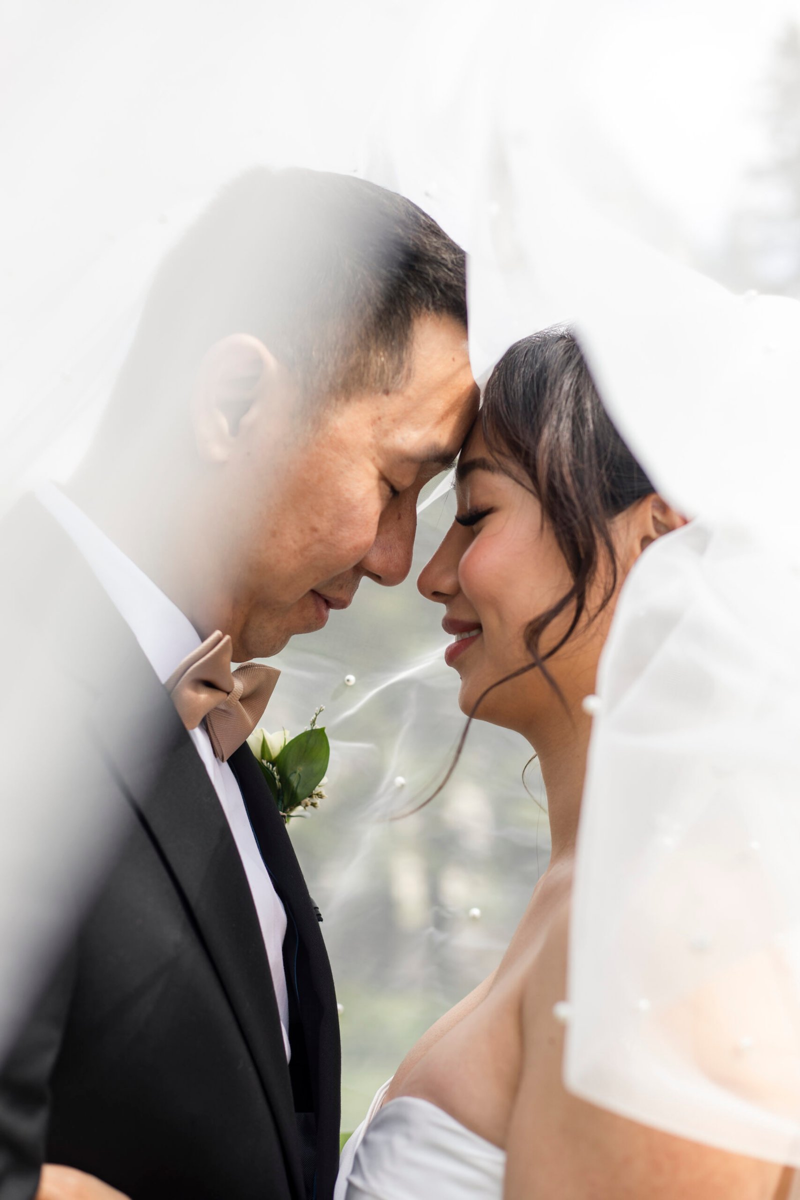 An eloping couple sharing a kiss in front of the historic Fairmont Château Laurier during a downtown Ottawa elopement