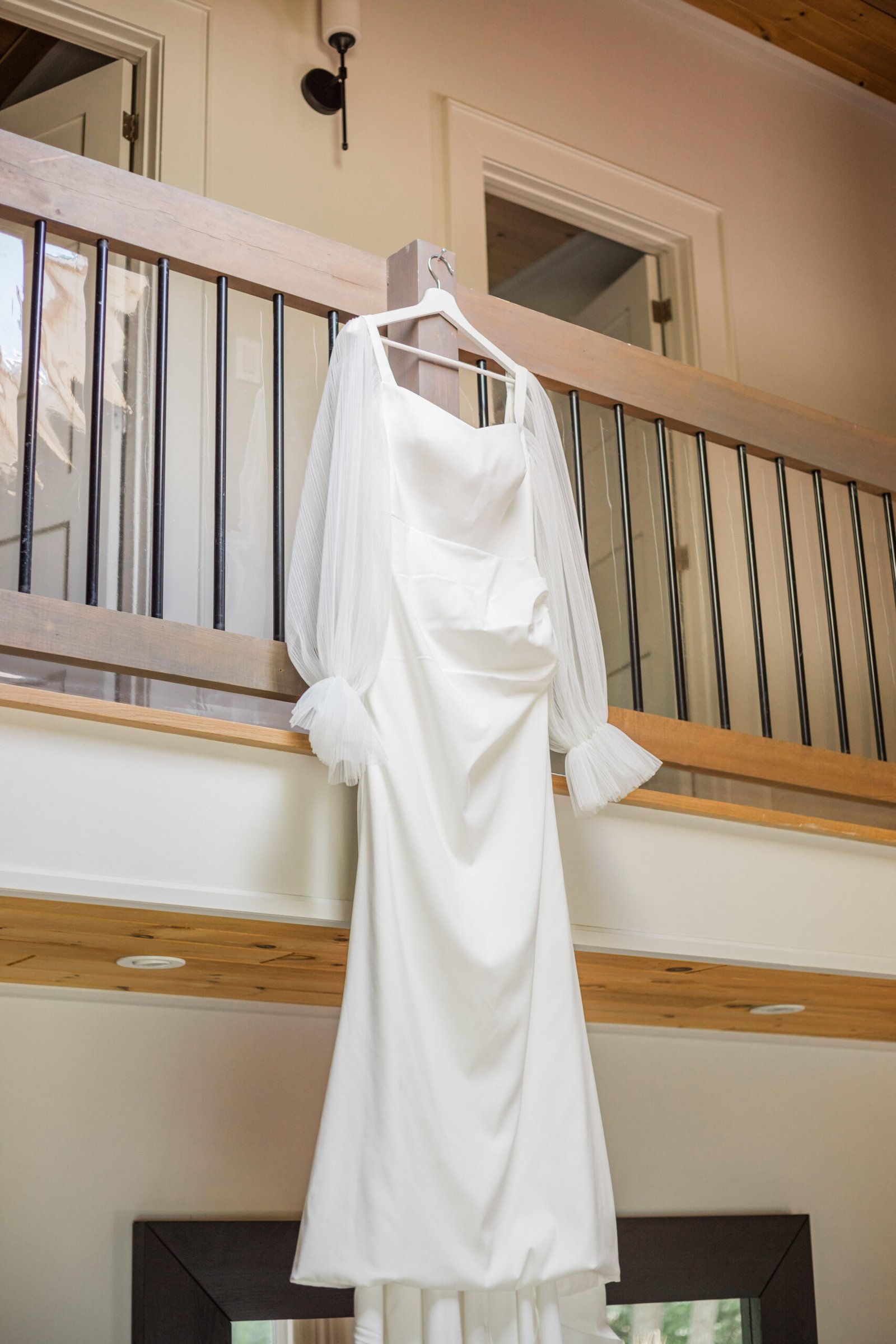 Wedding photography: white wedding dress with sheer sleeves hanging outdoors in natural light