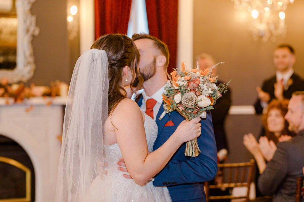 Toronto wedding couple kissing in front of a fireplace